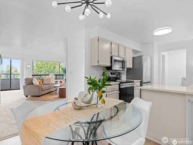 dining space featuring a chandelier and light colored carpet