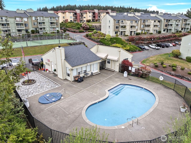 community pool with fence and a patio