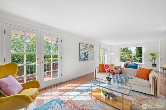 living area featuring french doors, visible vents, baseboards, and hardwood / wood-style flooring