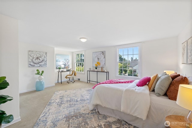 bedroom with carpet floors, multiple windows, and baseboards