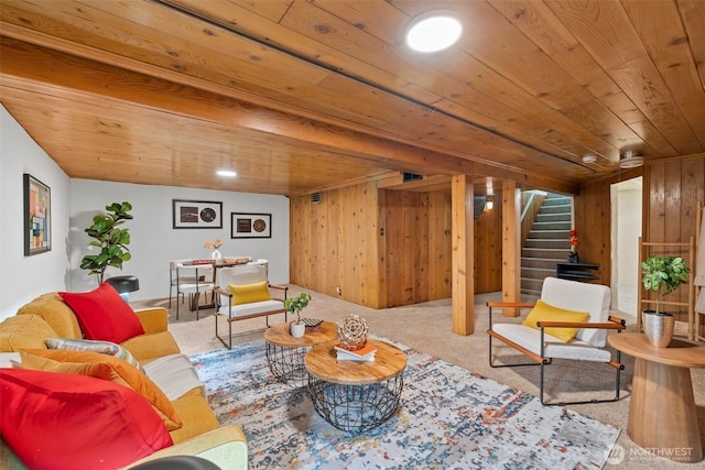 living area with carpet floors, wood walls, wood ceiling, and stairs