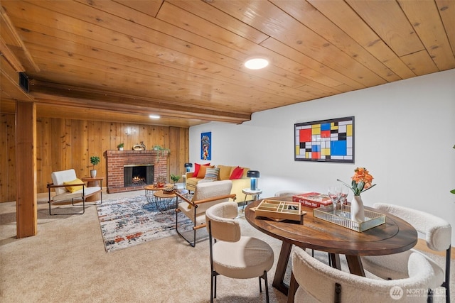 carpeted living area with wood walls, wood ceiling, and a fireplace