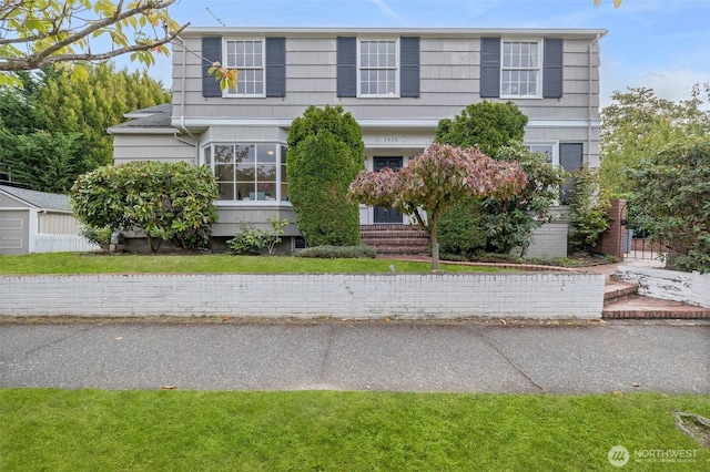 colonial inspired home with a front lawn