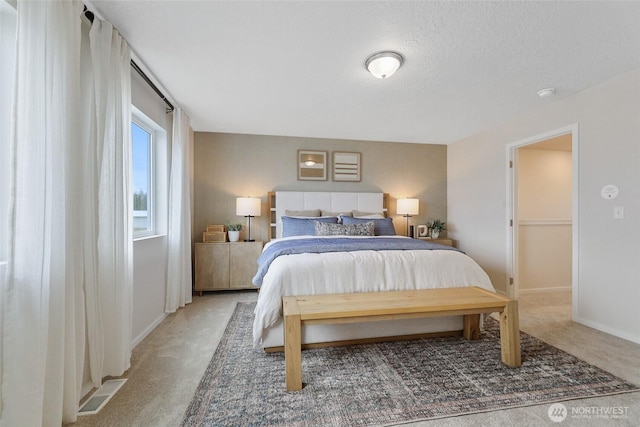 carpeted bedroom with baseboards and a textured ceiling