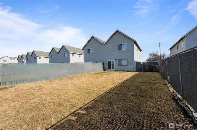 back of house featuring a fenced backyard and a yard