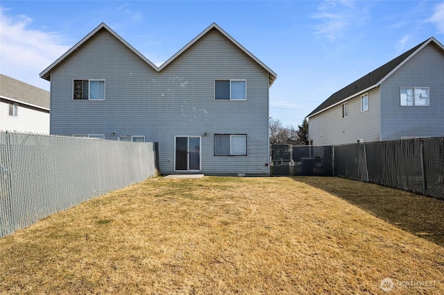 back of property featuring a fenced backyard and a lawn