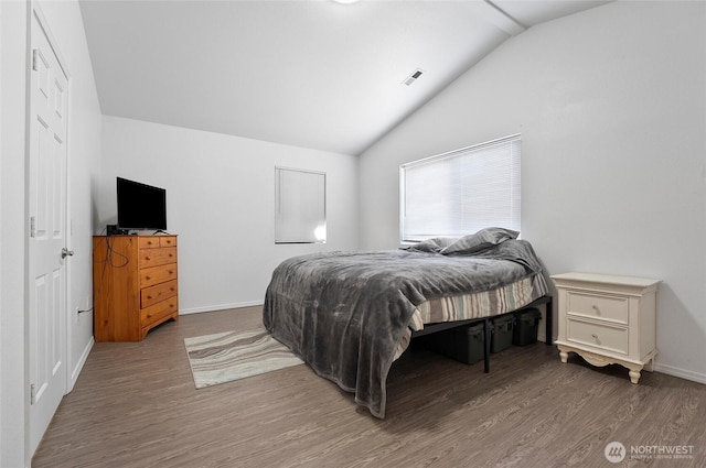 bedroom featuring vaulted ceiling, wood finished floors, visible vents, and baseboards