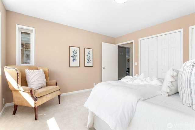 bedroom with light carpet, a closet, and baseboards