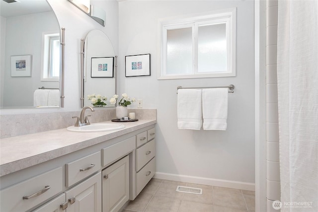 bathroom with baseboards, visible vents, vanity, and tile patterned floors