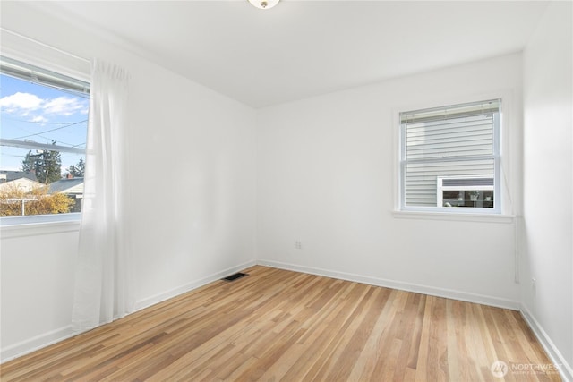 unfurnished room featuring visible vents, baseboards, and light wood-style flooring