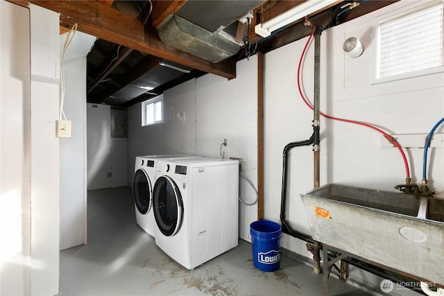 clothes washing area with laundry area, washing machine and dryer, and a sink