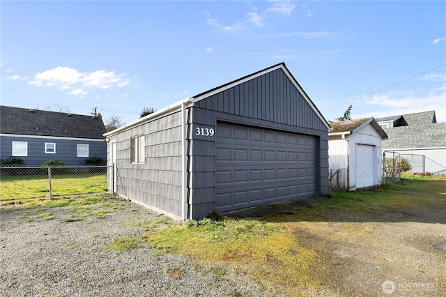 detached garage featuring fence