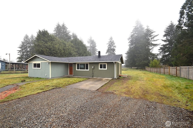 view of front of property featuring fence, driveway, and a front lawn