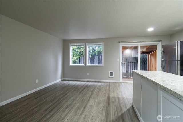 unfurnished living room with recessed lighting, baseboards, and wood finished floors