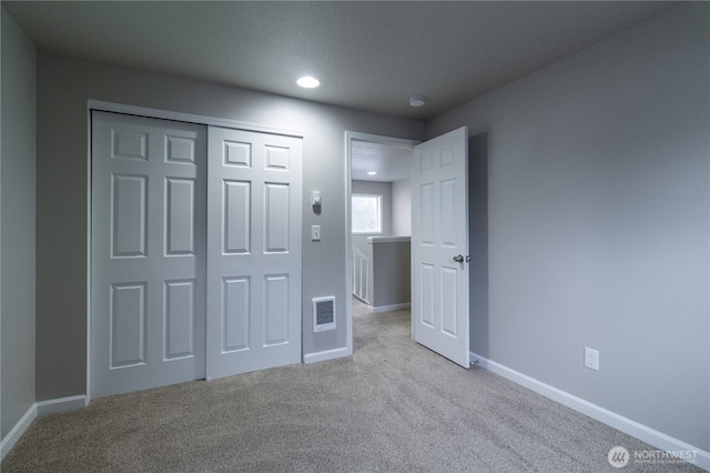 unfurnished bedroom with visible vents, baseboards, carpet, recessed lighting, and a closet