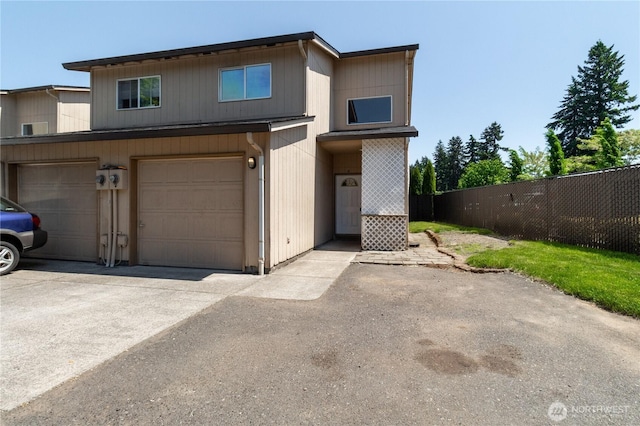 view of front of property with an attached garage, fence, and driveway