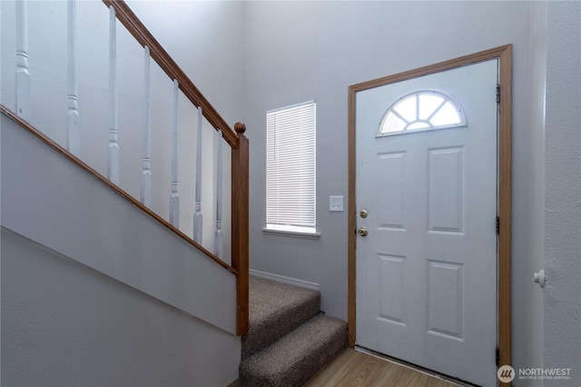 foyer featuring plenty of natural light, stairs, and light wood-style floors