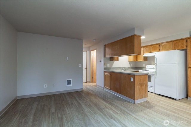 kitchen featuring white appliances, visible vents, under cabinet range hood, and light wood-type flooring