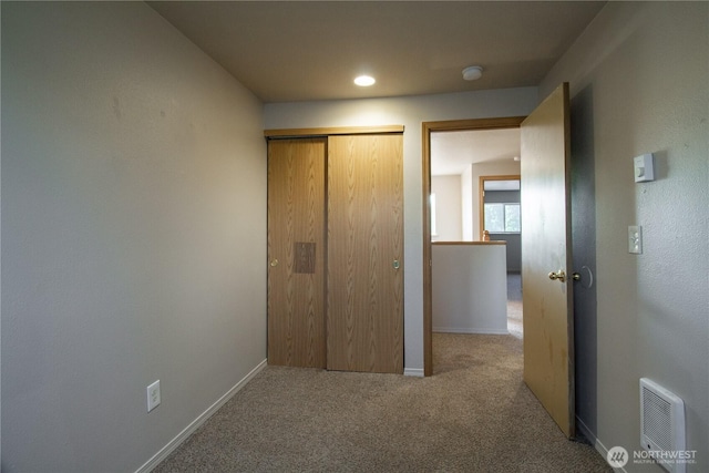 unfurnished bedroom with carpet flooring, visible vents, baseboards, and a closet