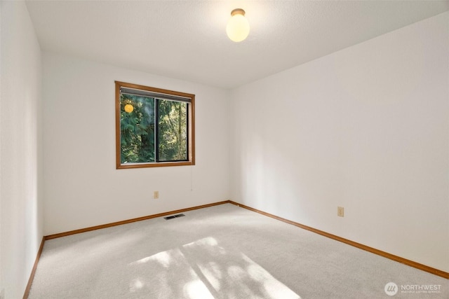 carpeted empty room with visible vents and baseboards