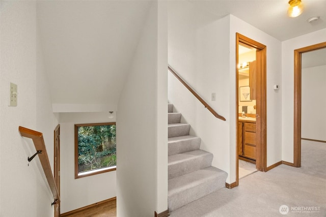 staircase with baseboards and carpet flooring