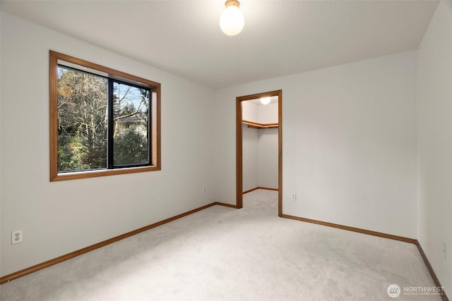 carpeted empty room with baseboards