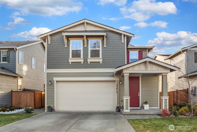 view of front of property with board and batten siding, fence, a garage, and driveway