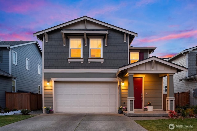 traditional-style house featuring concrete driveway, an attached garage, fence, and board and batten siding