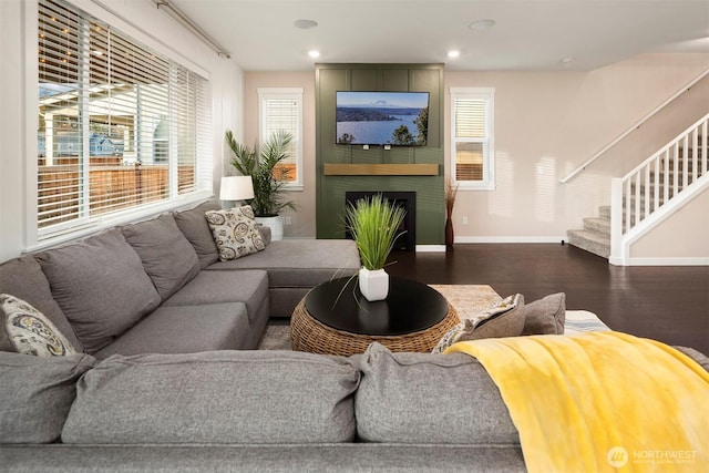 living area with dark wood-type flooring, baseboards, stairway, recessed lighting, and a fireplace