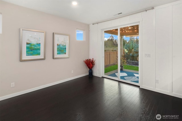 unfurnished room with dark wood finished floors, baseboards, and visible vents