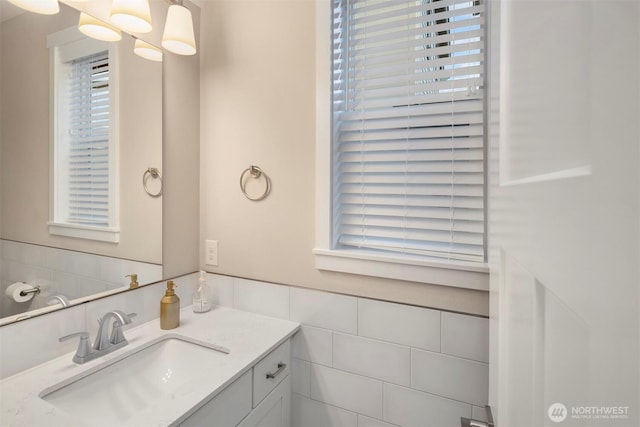 bathroom featuring a wainscoted wall, tile walls, and vanity