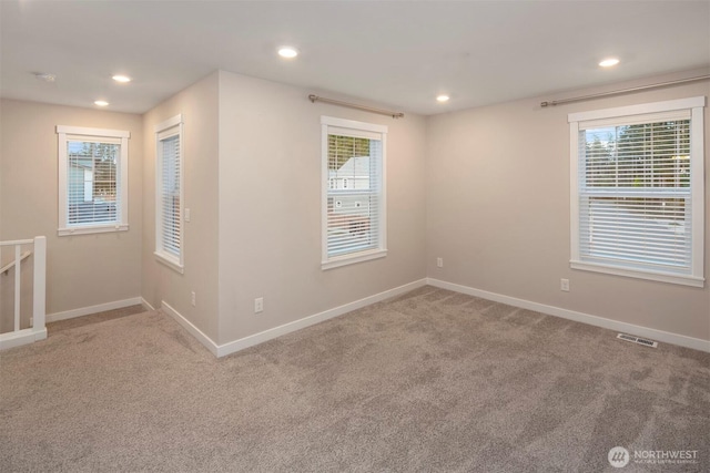 unfurnished room with visible vents, plenty of natural light, and baseboards