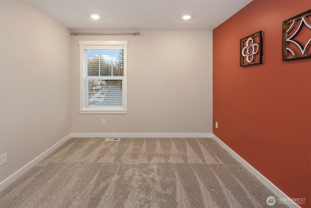 carpeted empty room featuring recessed lighting, visible vents, and baseboards