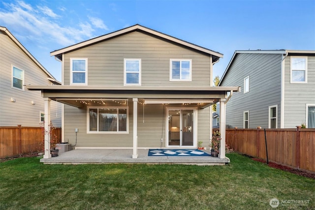 back of house with a yard, a patio, and a fenced backyard