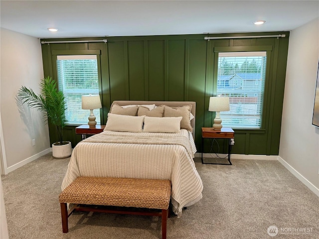 bedroom with baseboards and light colored carpet