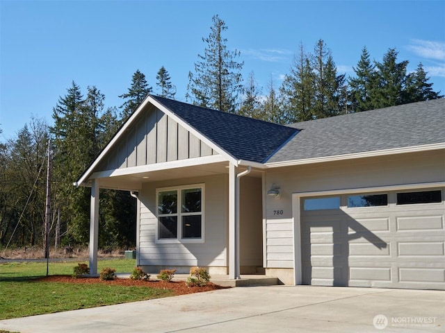 view of front facade with board and batten siding, concrete driveway, a shingled roof, and a garage