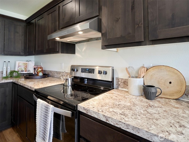 kitchen with light countertops, stainless steel range with electric cooktop, dark brown cabinets, wood finished floors, and under cabinet range hood