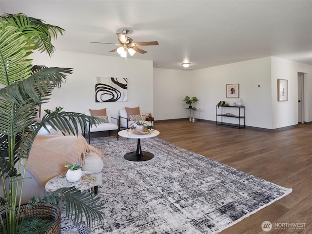 living area with ceiling fan, baseboards, and wood finished floors