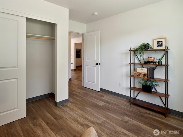 bedroom featuring a closet, baseboards, and wood finished floors