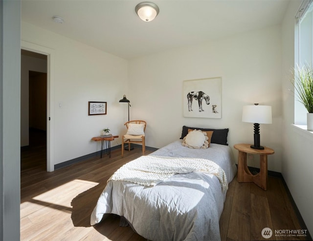 bedroom featuring wood finished floors and baseboards