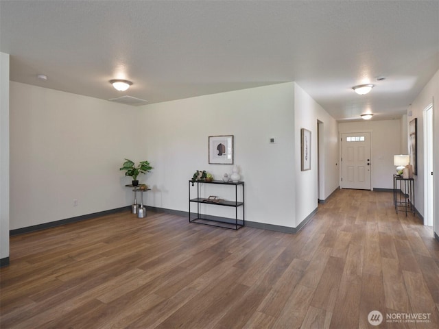 interior space featuring visible vents, baseboards, and wood finished floors