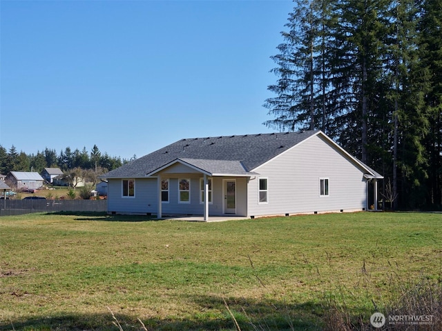 back of house with roof with shingles, a lawn, a patio area, and fence