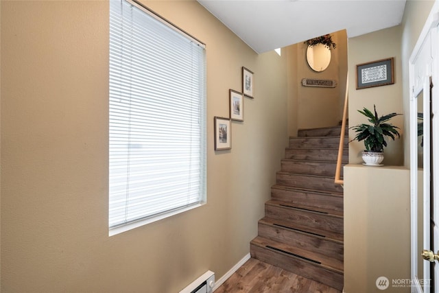 stairway with wood finished floors and baseboards