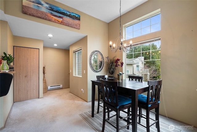 dining room with a baseboard heating unit, a chandelier, light colored carpet, recessed lighting, and a towering ceiling