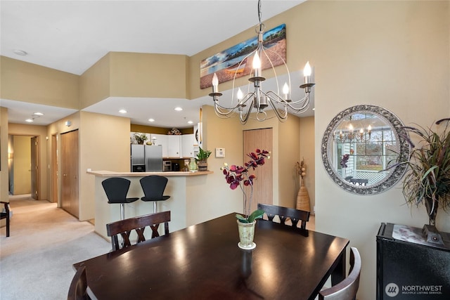 dining space featuring a notable chandelier, recessed lighting, and light carpet