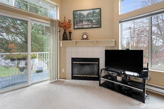 living area featuring carpet and a tile fireplace