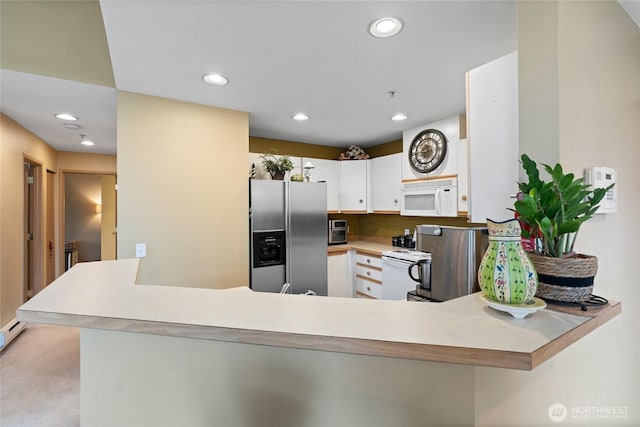 kitchen featuring white appliances, a peninsula, recessed lighting, light countertops, and white cabinets