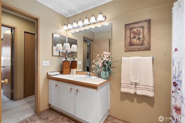 bathroom with vanity, baseboards, and wood finished floors