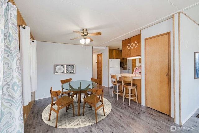 dining space with ceiling fan and wood finished floors