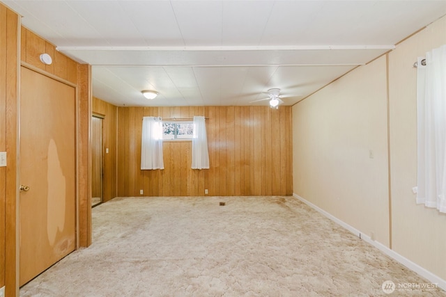 spare room with carpet floors and wood walls